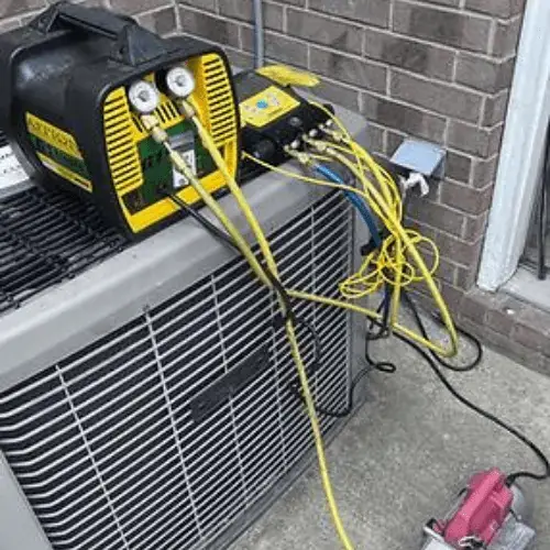 Manifold gauges clipped onto an outdoor condenser during an Osage diagnosis