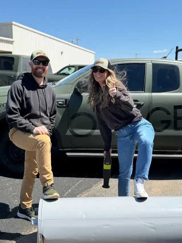 Two Osage Air crew members with duct pipe and the Osage truck