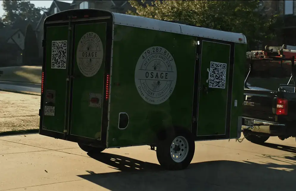 The green Osage trailer parked outside the shop